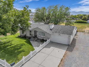 View of front of property with a garage, a mountain view, a shingled roof, brick siding, and driveway
