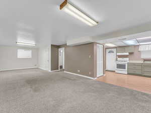 Unfurnished living room with light carpet and baseboards