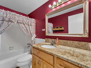 Full bath featuring vanity and shower / bathtub combination with curtain
