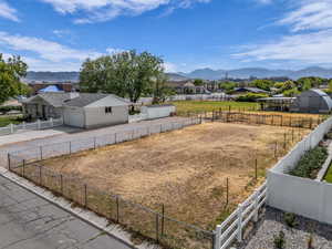 View of yard with a mountain view, driveway, and a garage