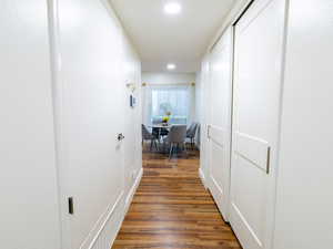Corridor with wood finished floors and recessed lighting