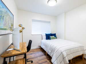 Bedroom with wood finished floors and multiple windows