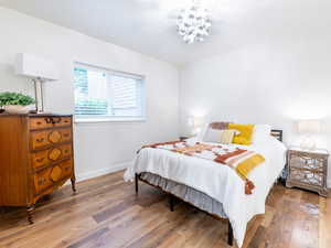 Bedroom featuring light wood-style floors and a chandelier