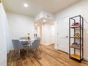 Dining room with wood-type flooring, washing machine and dryer, and recessed lighting