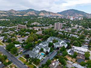 Aerial view of property and surrounding area with mountains and nearby urban area