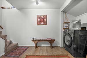 Washroom featuring washer / clothes dryer, wood finished floors, and baseboards