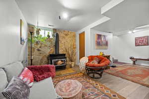 Living area with wood finished floors and a wood stove