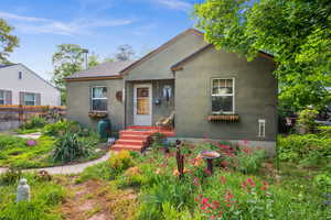 Bungalow-style home with stucco siding