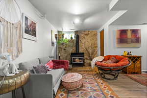 Living room featuring wood finished floors and a wood stove