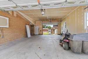 Garage featuring a garage door opener and a storage shed