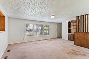 Empty room featuring carpet floors and a textured ceiling