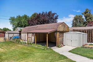 View of front of home with a shed and a shingled roof