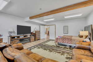 Living area with light wood-style floors and beamed ceiling