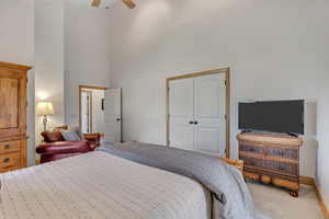Bedroom featuring a high ceiling, carpet floors, a closet, and ceiling fan