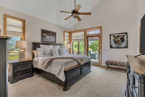 Bedroom with access to exterior, light colored carpet, a ceiling fan, and high vaulted ceiling