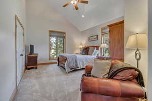Bedroom with multiple windows, high vaulted ceiling, light colored carpet, a ceiling fan, and recessed lighting