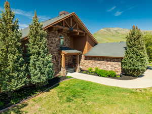 Craftsman house with stone siding, a front lawn, and a mountain view