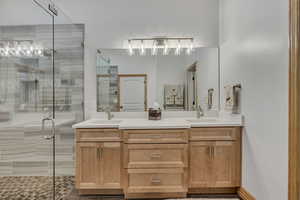 Full bathroom with double vanity and a stall shower