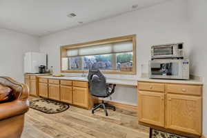 Office with a sink and light wood-type flooring