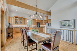 Dining room featuring light wood-style flooring, recessed lighting, high vaulted ceiling, and a chandelier