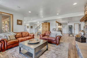 Living room with light wood-style floors, stairway, and recessed lighting