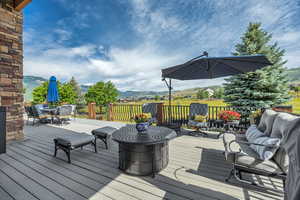 Deck with a mountain view, outdoor dining space, and an outdoor living space
