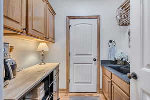 Laundry area with light wood-type flooring and cabinet space