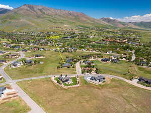 Aerial view of property's location featuring a mountain backdrop and nearby suburban area