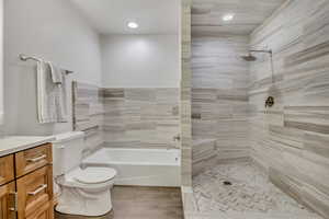Bathroom with vanity, a tile shower, a bathtub, and recessed lighting