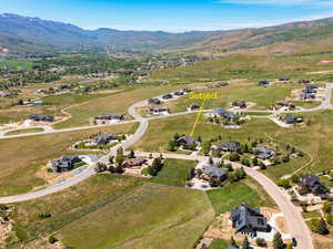 Aerial view of property's location featuring a mountainous background