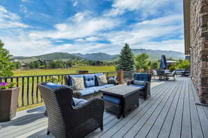 Deck with a mountain view, an outdoor hangout area, and outdoor dining area