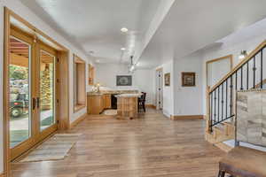 Kitchen featuring light wood-style floors, a center island, recessed lighting, black dishwasher, and french doors