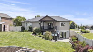 View of front of property with french doors, a fenced backyard, a storage unit, a gate, and a shingled roof