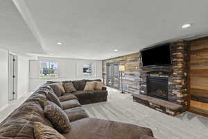 Carpeted living room featuring a textured ceiling, a fireplace, and recessed lighting