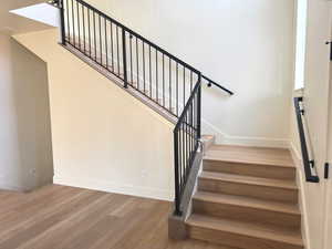 Staircase with baseboards and wood finished floors