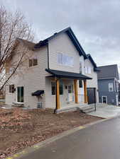 View of front facade with concrete driveway, a porch, and a garage