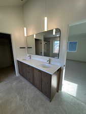 Bathroom featuring a shower stall, double vanity, and a towering ceiling
