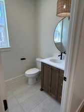 Half bathroom featuring light tile patterned flooring and vanity