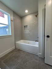 Full bathroom featuring shower / washtub combination, recessed lighting, and dark tile patterned floors