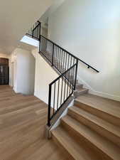 Stairway with baseboards and wood finished floors