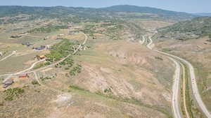 Aerial view of property and surrounding area with a mountainous background and rural landscape