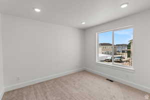Carpeted empty room with recessed lighting