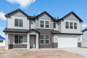 Craftsman-style home featuring stone siding, concrete driveway, and a garage