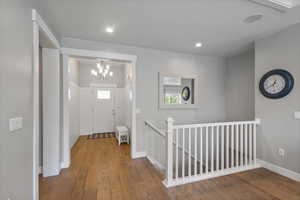 Foyer entrance with a chandelier, wood finished floors, plenty of natural light, and recessed lighting