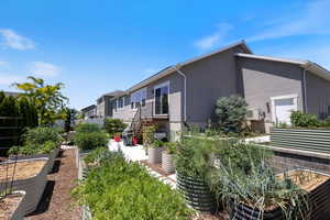 View of side of home with a garden and stucco siding