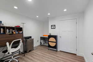 Office space with light wood-type flooring and recessed lighting