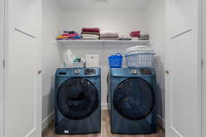 Laundry room featuring washing machine and clothes dryer and wood finished floors