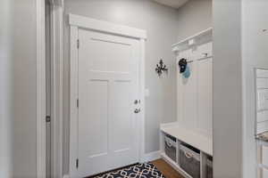Mudroom featuring dark wood-type flooring and baseboards