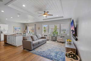 Living area with light wood-style floors, a ceiling fan, and recessed lighting