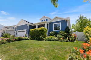 View of front of house with an attached garage and roof mounted solar panels